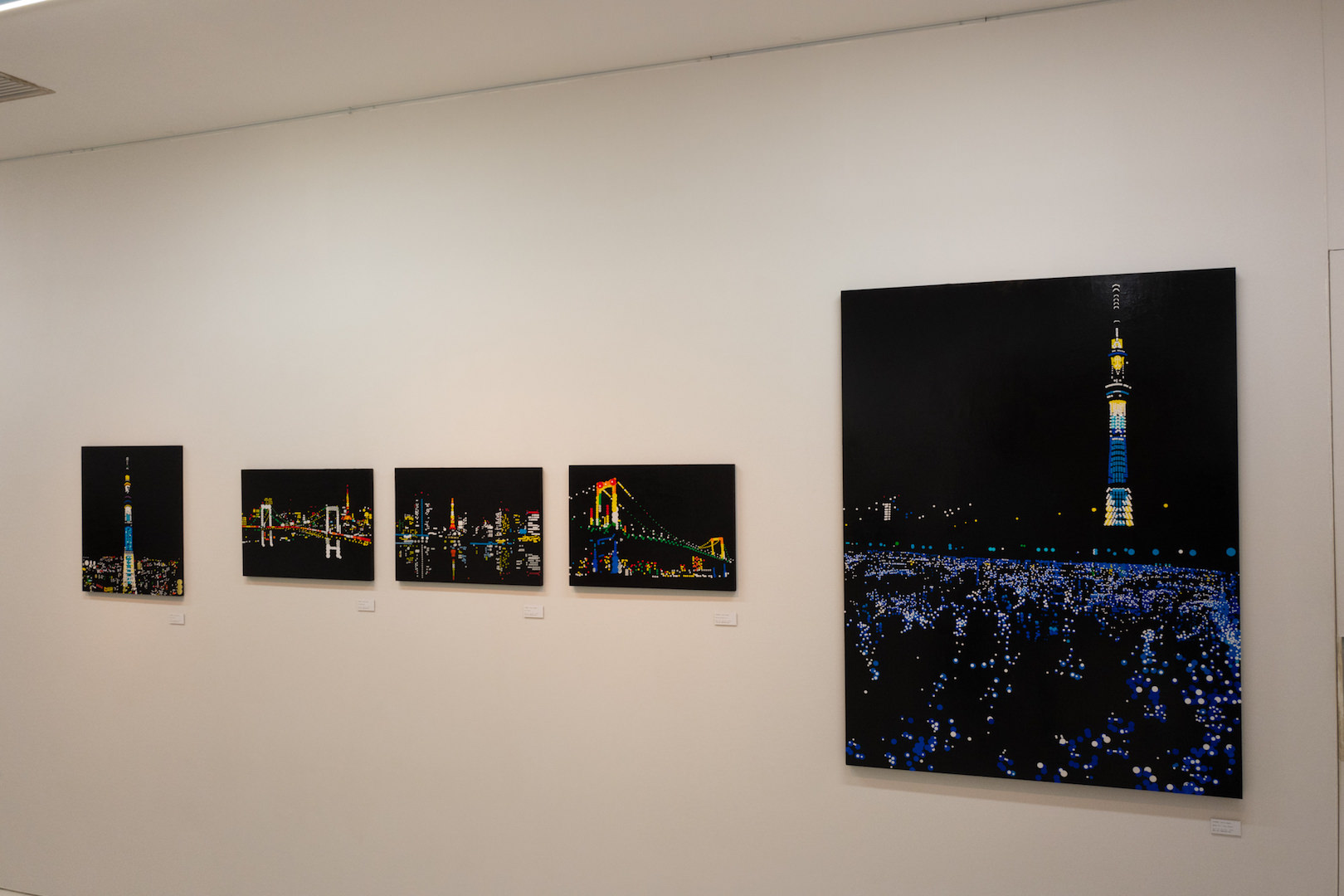 右作品：大村雪乃 《東京ホタル》 2018年 丸シール、アクリル、パネル 1,303 x 970 mm